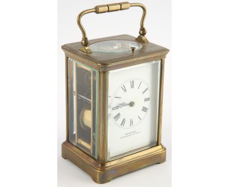 A late 19th century brass cased carriage clock with visible escapement and push button repeat over an enamelled dial detailed