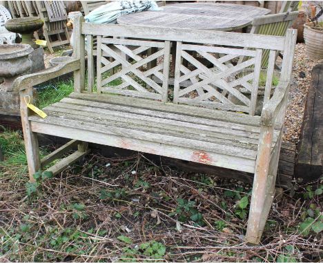 A teak garden bench, the back with Chinese lattice form panels, above slatted seat, 100cm high x 130cm wide x 65cm deep