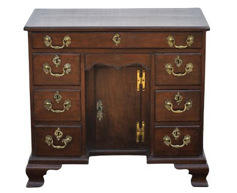 A George II mahogany kneehole dressing table, the moulded cleated top with cusped corners, the central cupboard door enclosed