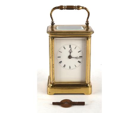 An early 20th century gilt brass cased carriage clock with visible escapement, white enamel dial and a two train movement wit