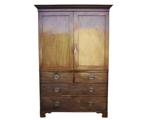A George III mahogany linen press, the moulded cornice above a pair of panel doors, interior now void, below are two short an