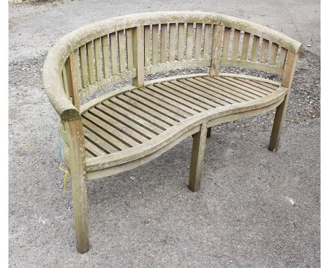 A semi-circular teak garden bench, 85cm high x 160cm wide x 67cm deep