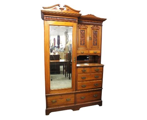 A late Victorian walnut wardrobe, 1890s, the bevelled mirror panel door above a drawer, flanked by a recessed pair of cupboar