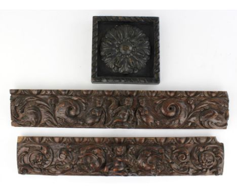 Two 17th century carved panels, Flemish, one with a central cherub enclosed by dolphins and scrolling vine and berries, the o