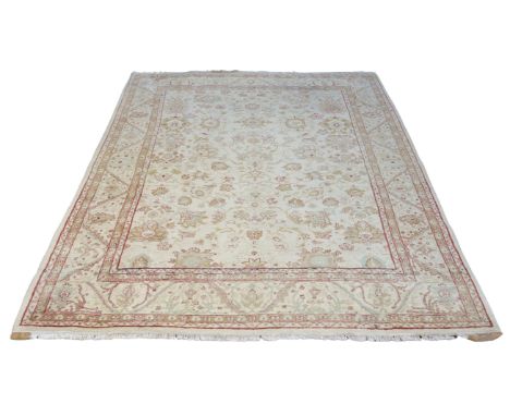 A Mahindra Black Mountain Looms carpet, with large flower filled field, woven in pistachio, red and green, on a cream ground,