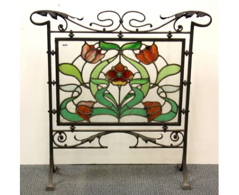 An Art Nouveau wrought iron and stained glass fire screen, W. 90cm, H. 91cm, (some glass A/F).