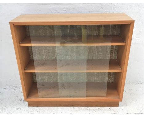 LIGHT TEAK BOOKCASEwith a rectangular top now applied with a light oak transfer, above a pair of glass sliding doors and two 