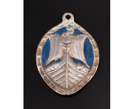 ALEXANDER RITCHIE IONA SCOTTISH SILVER AND ENAMELLED PENDANT of elliptical form, depicting a ship, with turquoise coloured en