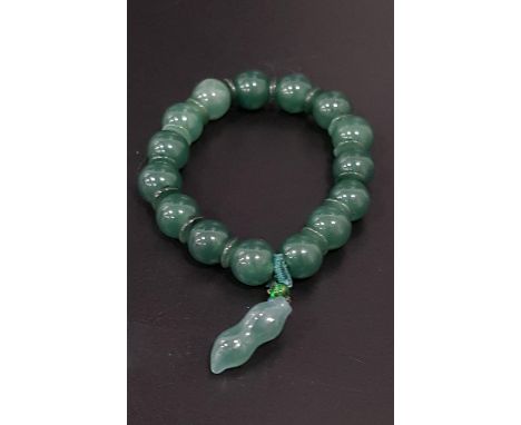 JADE COLOURED HARD STONE BEAD BRACELETwith fifteen beads and a shaped charm attachment 
