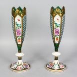A GOOD PAIR OF BOHEMIAN TALL SLENDER WHITE OVERLAY, RUBY AND GILT VASES painted with panels of