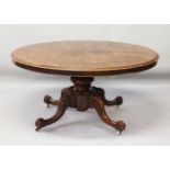 A VICTORIAN FIGURED WALNUT OVAL LOO TABLE, with centre column support, four curving legs ending in