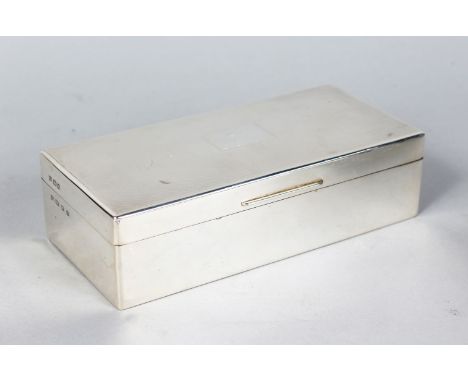 A RECTANGULAR SILVER CIGARETTE BOX, with engine turned top. 7.5ins long.  London 1983.