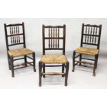 A SET OF THREE ELM SPINDLE BACK SINGLE CHAIRS with rush work seats.
