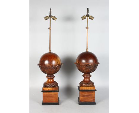 A PAIR OF 20TH CENTURY CARVED WOOD SPHERICAL TABLE LAMPS, on square plinths. 2ft 6ins high (including lamp fittings).