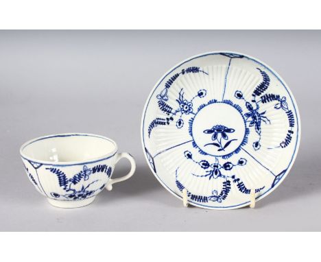AN 18TH CENTURY WORCESTER TEACUP AND SAUCER painted in under-glaze blue with the Immortelle pattern.