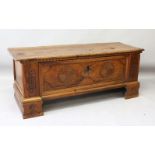 AN 18TH CENTURY ITALIAN WALNUT CASSONE, with plain plank top, carved front with two roundels and