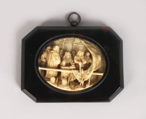 A EUROPEAN OVAL CARVED PLAQUE in a tortoiseshell frame. 2.5ins x 3.25ins.