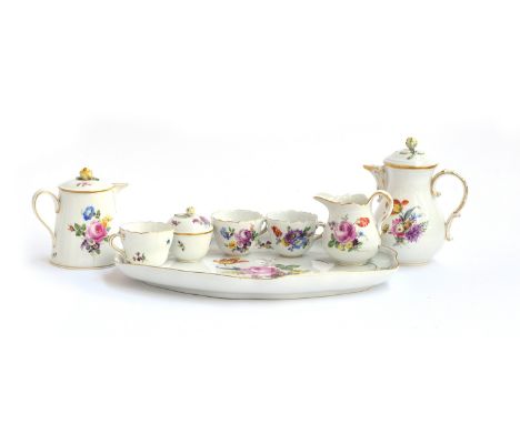 A Meissen part tea service, c. 1924, comprising teapots, teacups, lidded sugar bowl, milk jug and tray, with hand painted flo