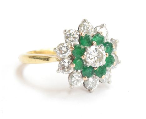 An 18ct gold diamond and emerald cluster ring, approximately 1 carat of diamonds comprising of 1 central diamond surrounded b