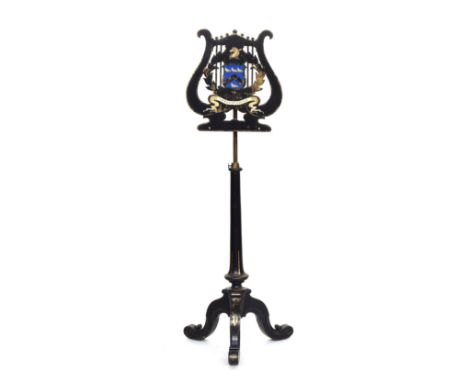 A Victorian ebonised music stand by Jennens &amp; Bettridge, the lyre form top with armorial crest depicting horse with arrow