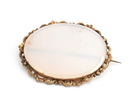 A pale jade brooch of oval form set within an unmarked gold, pierced border approx. 6 x 5cm 