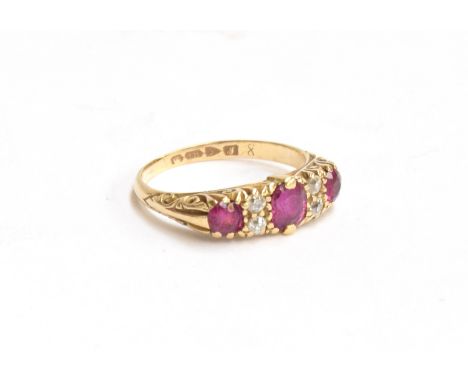 An 18ct gold dress ring set with 3 rubies and 4 small diamonds on a decorated shank, gross weight 3.8g, size O 