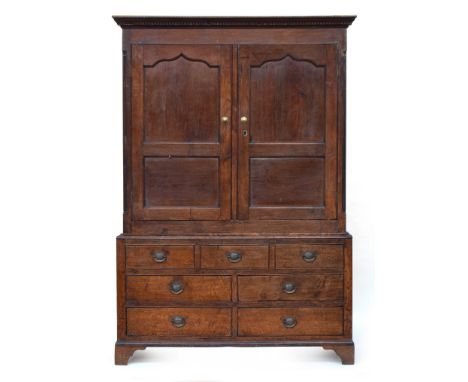 George III oak press cupboard, enclosed by panelled doors, on a base comprising three blind drawers, over four drawers, on br