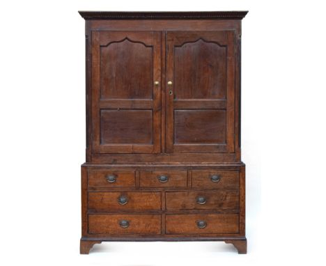 George III oak press cupboard, enclosed by panelled doors, on a base comprising three blind drawers, over four drawers, on br