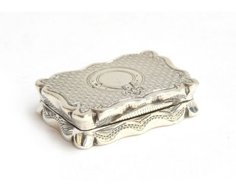 A Victorian silver vinaigrette by Frederick Marson, Birmingham 1875, rectangular form with shaped outline, engine turned with