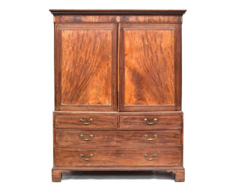A Regency mahogany linen press, dentil cornice over panelled marquetry cupboard doors, above two short and two long drawers, 