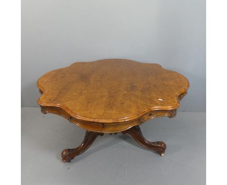 A Victorian burr-walnut veneered tilt-top loo table raised on ornately carved tripod base. Length 132cm, height 73cm.