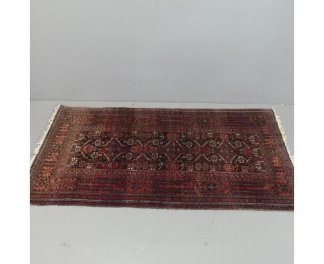 A red-ground Persian rug. Length 183cm, width 92cm.