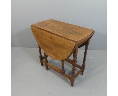 An early 20th century oak gate-leg drop-leaf table with barley-twist supports. Width 76cm, height 73cm, depth 42cm.