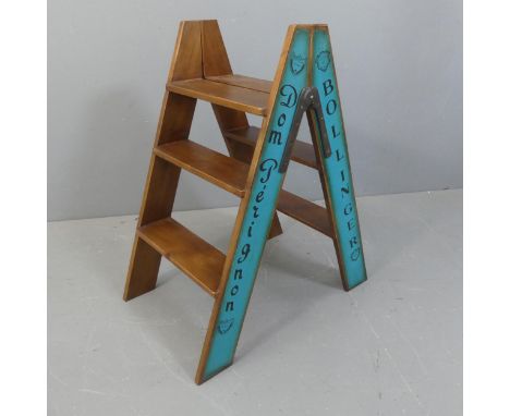A modern stained pine folding step stool with champagne themed painted decoration. Width 45cm, Height 80cm, Depth 68cm.