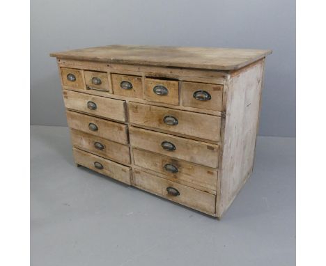 A Vintage pine workshop bank of thirteen drawers / shop counter. Width 129cm, height 89cm, depth 70cm.Has a panelled back sug
