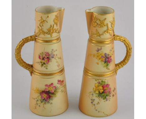 A pair of Royal Worcester blush porcelain ewers, pattern 1047, the tapering bodies moulded and painted with floral sprays, ap