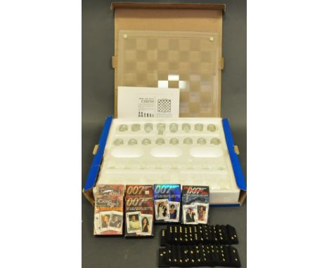 A glass chess set, one side in clear glass, the other frosted, with glass board, in original box, together with six decks of 