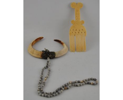 A late 19th/ early 20th Century African carved ivory comb with geometric and a dot carving H:17cm together with a tusk amulet