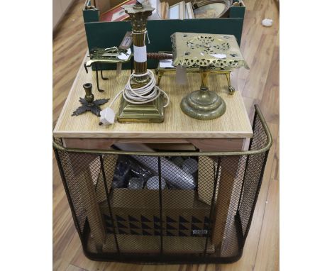 Three brass trivets, a brass stand, a fireguard and a brass Corinthian column table lamp