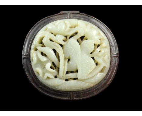 A carved jade plaque, depicting a long-necked bird amongst flowers and leaves, in hardwood mount, plaque 8 cm wide .    