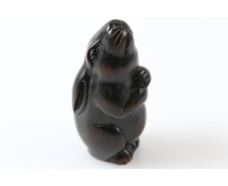 Early 20th century Japanese carved hardwood netsuke of a hare gazing up at the moon, signed on round inlaid bone panel, 6cm h