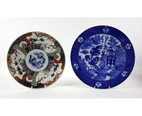 Two Japanese chargers, the first decorated in blue and white with a pagoda, character stamp underneath, 37 cm diam., the seco