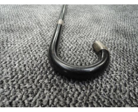 An ebonised walking stick having HM silver ferrule and tip