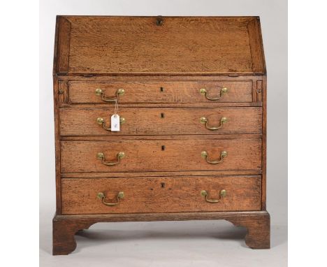 A GEORGE III OAK BUREAU, C1780, THE FALL-FLAP REVEALING CONVENTIONALLY FITTED INTERIOR OF PIGEON HOLES AND DRAWERS, ABOVE PAI