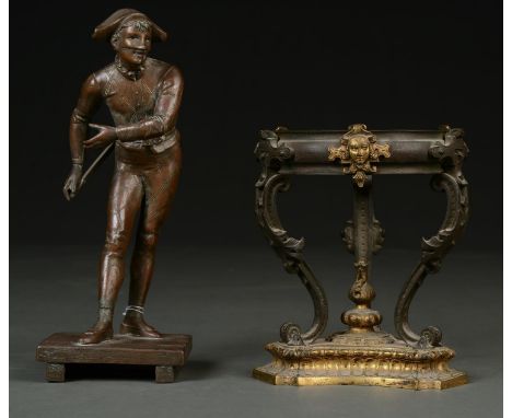 A FRENCH BRONZED SPELTER STATUETTE OF A CLOWN AND A PATINATED BRASS OIL LAMP BASE ON THREE SCROLLING LEGS AND TRIFORM CAVETTO