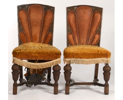 A PAIR OF OAK ART DECO STYLE DINING CHAIRS, WITH FLORAL CARVED BACKS WITH STUFFED OVER BROWN LEATHER FLUTED AND PIPED PANEL, 