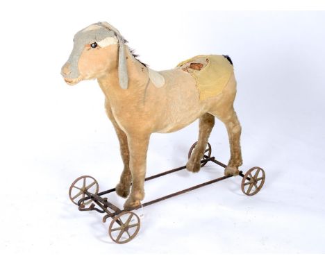 A CHILD'S PULL-ALONG DONKEY, C1900, THE STRAW STUFFED BODY COVERED IN PALE GOLD PLUSH WITH BLACK BOOT BUTTON EYES, ON BLACK A