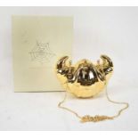 CHARLOTTE OLYMPIA; a gold plated brass croissant clutch.