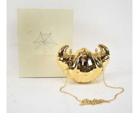 CHARLOTTE OLYMPIA; a gold plated brass croissant clutch.