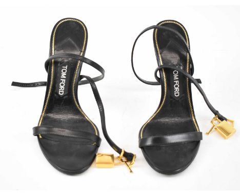 TOM FORD; a pair of black leather strappy stiletto sandals with gold padlock details, heal 12cm, size 38.5cm.